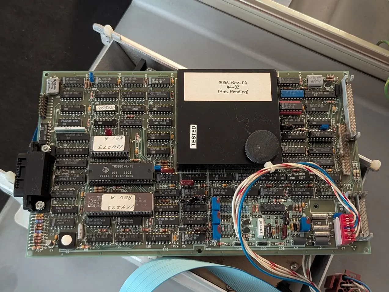 board about the size of a sheet of paper with a large black potted electronics module on top. it reads "9056-Rev. 04   44-82   (Pat. Pending)"