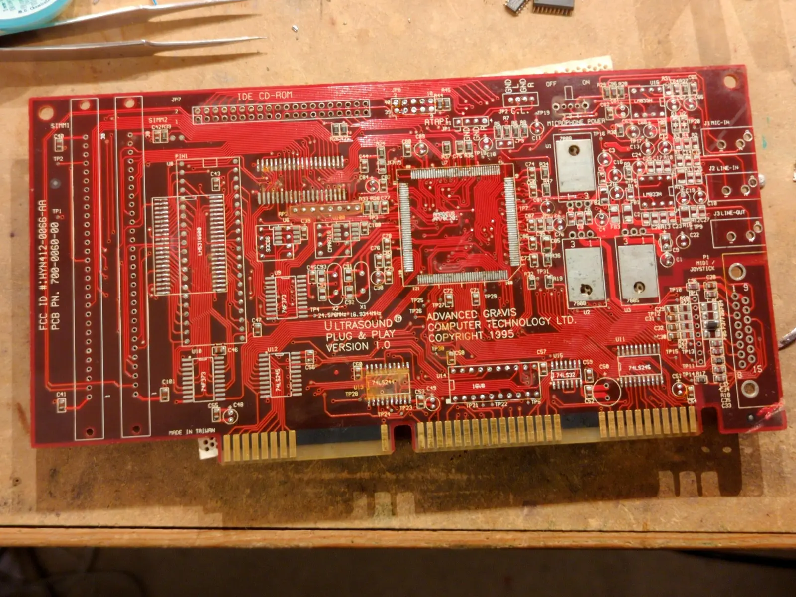 a red board nearly stripped bare of components.