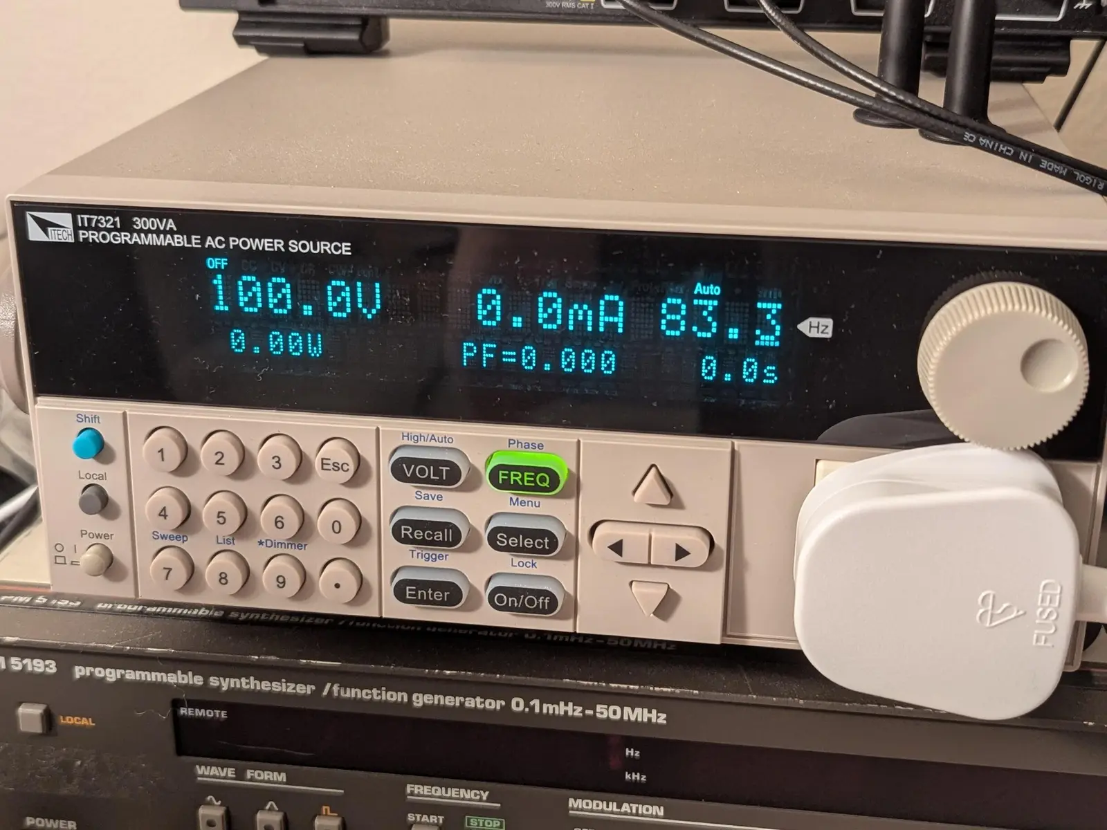 a programmable AC power supply with a British plug installed in the front panel. it's set to 100V at 83.3Hz.