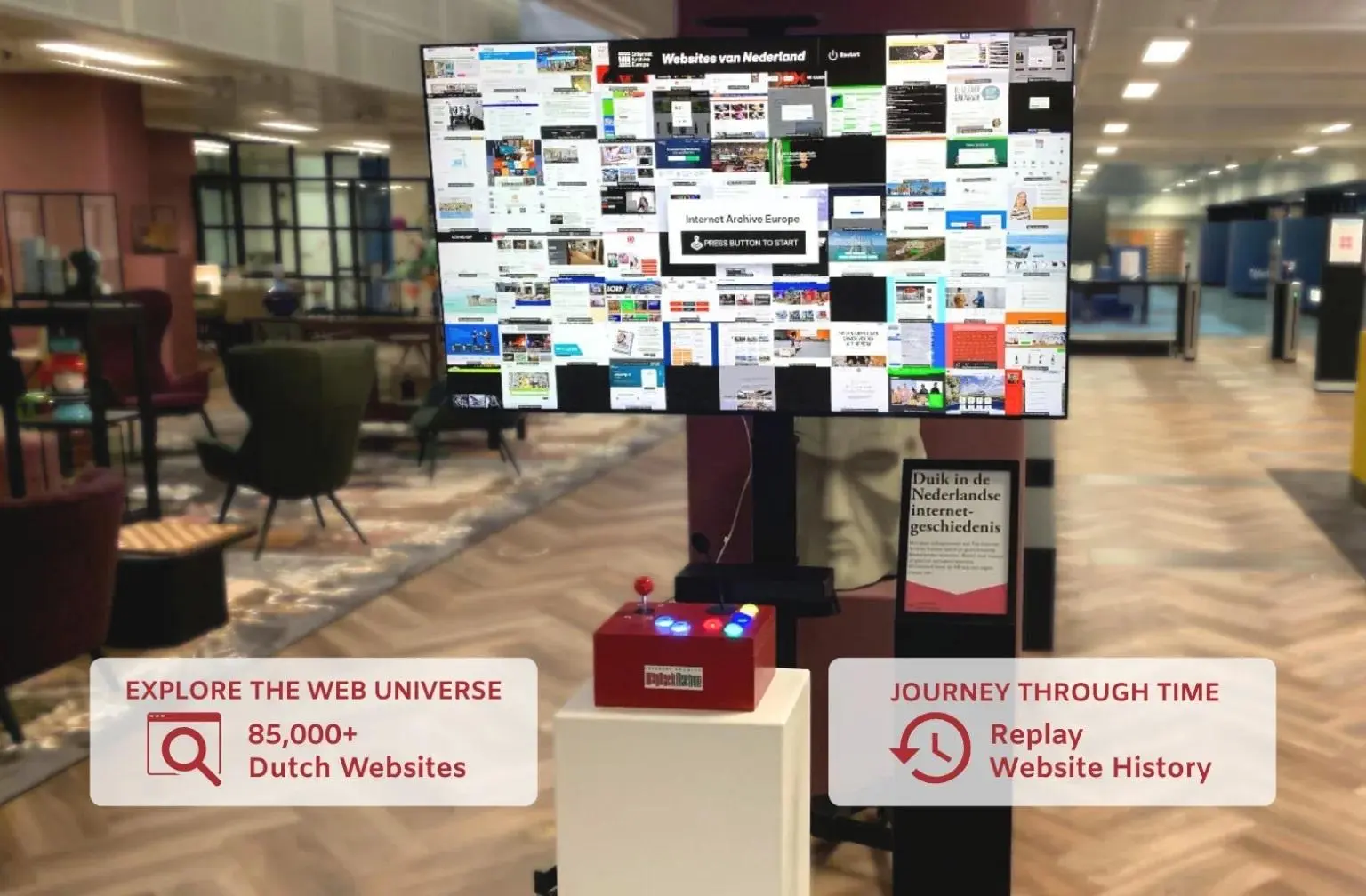The Internet Archive Europe "Websites van Nederland" interactive kiosk installed in a public space, featuring a large screen displaying a mosaic of archived Dutch website screenshots with a "Press Button to Start" prompt, and a red arcade-style controller box with colored buttons and joystick on a white pedestal. A secondary information panel in Dutch stands alongside. Overlaid text reads "Explore the Web Universe: 85,000+ Dutch Websites" and "Journey Through Time: Replay Website History." Photo: Preserving Digital Sovereignty: Marleen Stikker &amp; Brewster Kahle at the KB by Sebastiaan ter Burg, CC BY 4.0